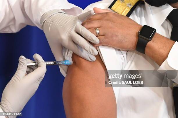 Surgeon General Jerome Adams receives the COVID-19 vaccine in the Eisenhower Executive Office Building in Washington, DC, December 18, 2020.