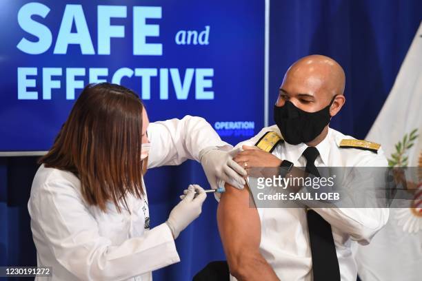Surgeon General Jerome Adams receives the COVID-19 vaccine in the Eisenhower Executive Office Building in Washington, DC, December 18, 2020.