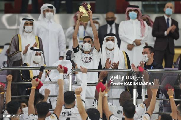 Sadd's midfielder and captain Hassan al-Haidos lifts the trophy presented by Qatar's Emir Sheikh Tamim bin Hamad Al-Thani after al-Sadd won the Amir...