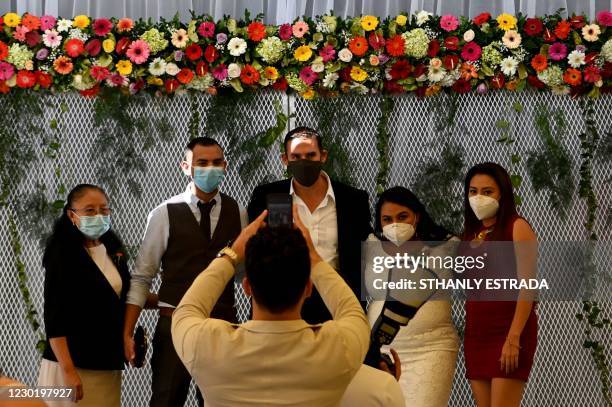 Newly-wedded couples and relatives pose for a picture during a mass wedding attended by 79 couples at Cuscatlan Park in San Salvador, on December 18,...