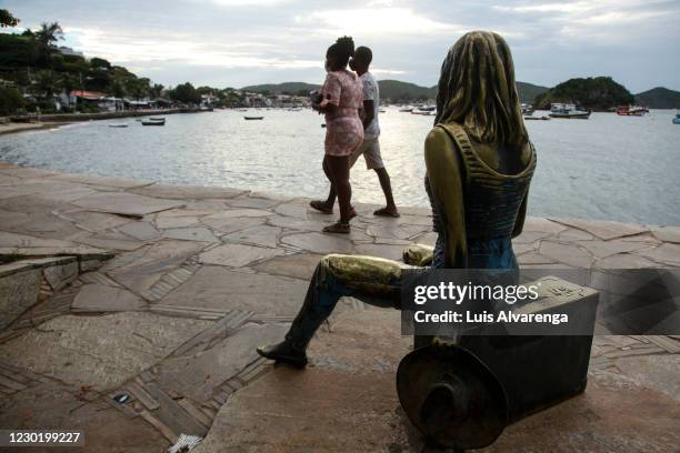 Tourists walk next to a Brigitte Bardot statue at Orla Brigitte Bardot after the decision of the Rio de Janeiro State Justice to reverse the closure...