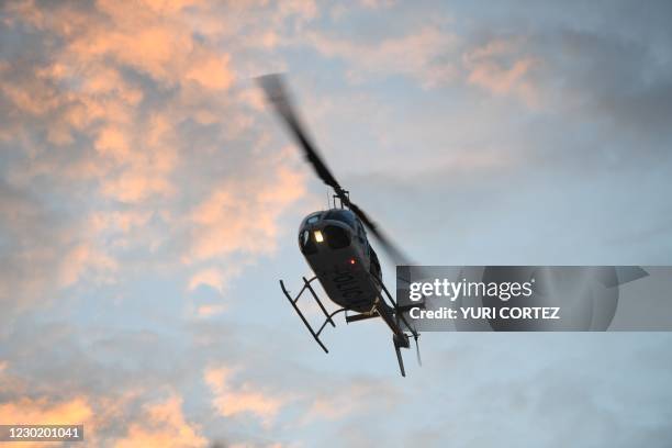 Helicopter of the Venezuelan police flies over the coast during the search operation for Venezuelan migrants who apparently died when a boat...