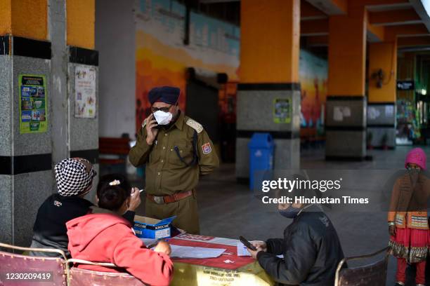 Police personnel registers for coronavirus screening at Hazrat Nizamuddin Railway Station , on December 19, 2020 in New Delhi, India.