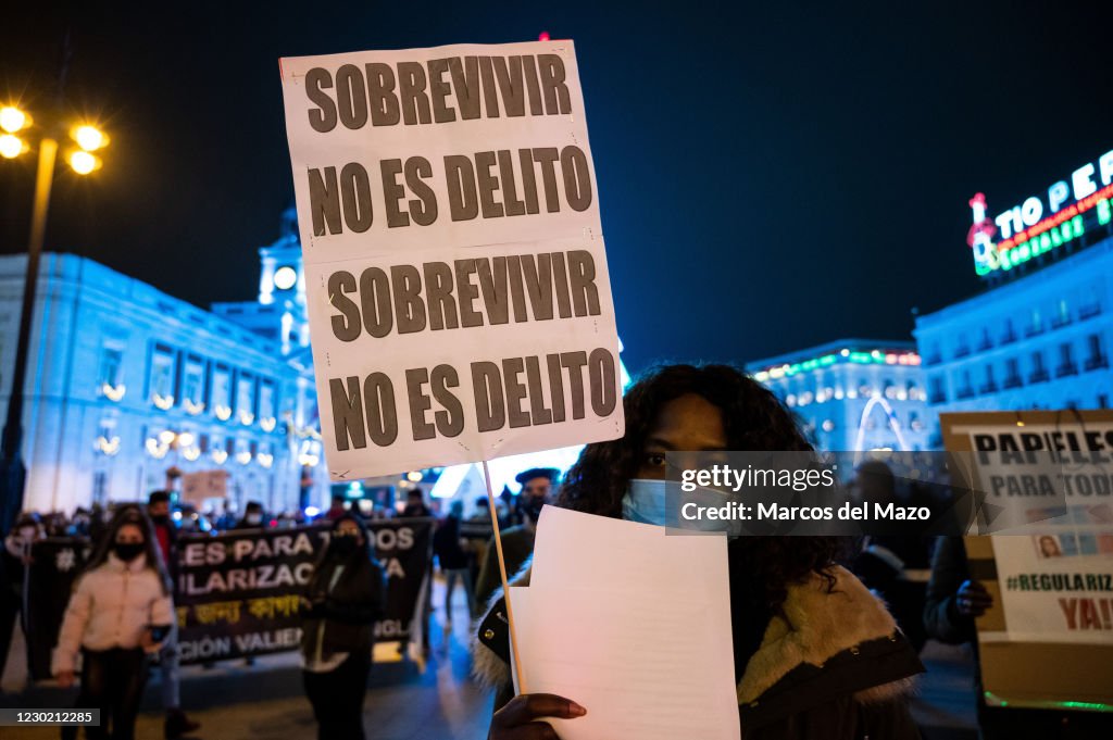 A woman holding a placard reading 'Surviving is not a crime...