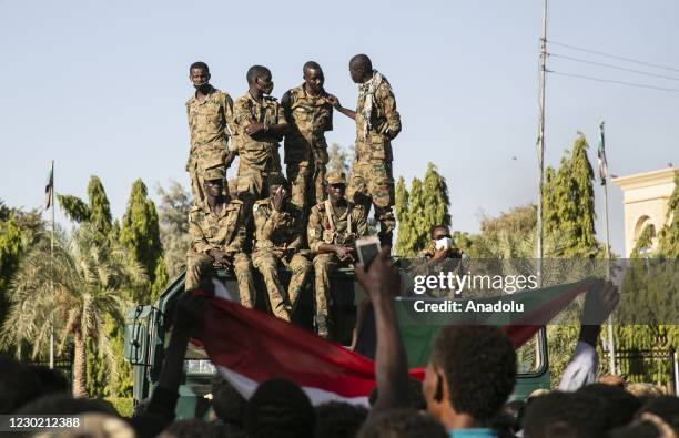 Sudanese security forces stand guard as Sudanese demonstrations wearing face masks gather to protest against Sudanese government to mark the second...