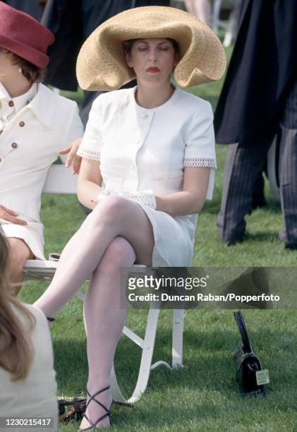 English fashion editor Isabella Blow attending an event wearing a flamboyant hat, circa 1990.