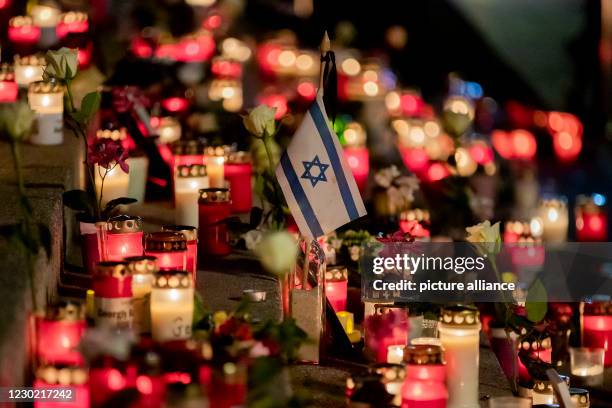 December 2020, Berlin: An Israel flag stands between memorial candles at the Goldener Riss memorial during the commemoration on the fourth...