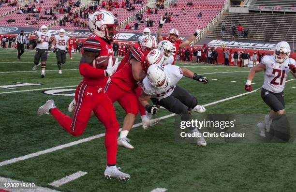 Clark Phillips III of the Utah Utes runs back a fumble recovery for a touchdown, as he is chased by Liam Ryan and Max Borghi of the Washington State...