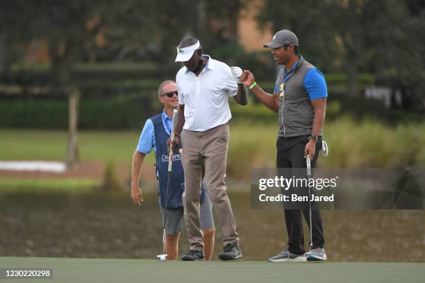 Vijay Singh of Fiji and his son Qass Singh fist bump after making a putt on the 17th green during the first round of the PGA TOUR Champions PNC...