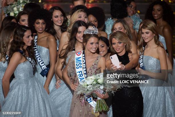 Miss Normandie Amandine Petit poses for a selfie with Miss France Organisation general director Sylvie Tellier and contestants the end of the Miss...