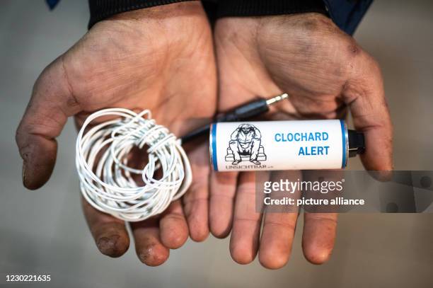 December 2020, North Rhine-Westphalia, Wuppertal: Homeless Björn holds an alarm system, the so-called "Clochard Alert", in his hands in the inner...