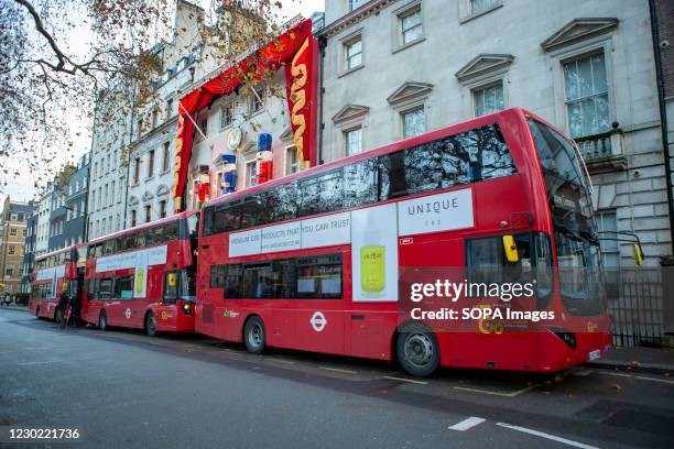 Three London Buses lined up in front of Annabel's Club Mayfair.