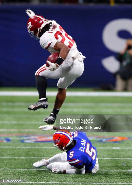 Running back Najee Harris of the Alabama Crimson Tide leaps over defensive back Kaiir Elam of the Florida Gators in the second half of the SEC...