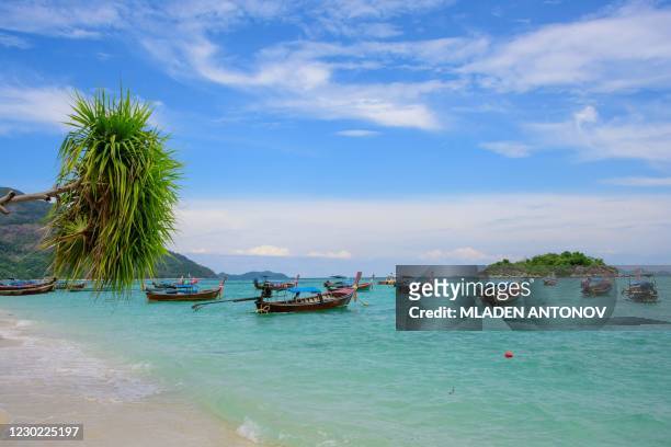 This photograph taken on December 19, 2020 shows longtail boats moored at a beach on Koh Lipe island in the Andaman Sea.