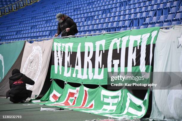 Disappointed FC Gifu supporters clear the banner after the loss during the J.League Meiji Yasuda J3 match between Gamba Osaka U-23 and FC Gifu at...