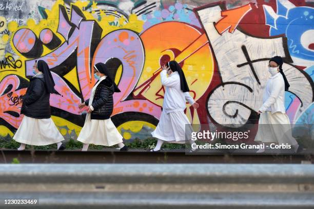 Nuns walk in front of the murals in Tor Bella Monaca,on December 20, 2020 in Rome, Italy. Dozens of writers, muralists and street artists paint the...