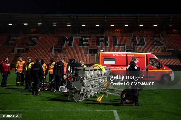 Members of the medical staff and firemen try to rescue a man in critical conditions, who's lying on the football picth after he was hit by the fall...