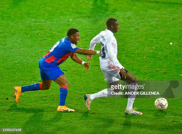 Eibar's Senegalese midfielder Pape Diop challenges Real Madrid's French defender Ferland Mendy during the Spanish league football match between SD...