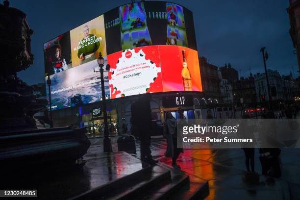 Christmas themed billboard illuminates Piccadilly Circus on December 21, 2020 in London, England. London and large parts of southern England were...