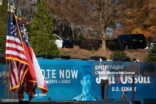Georgia Democratic Senate candidate Jon Ossoff walks on stage and waves at the crowd during a drive-in rally at Bibb Mill Event Center on December...