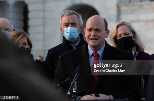 Rep. Tom Reed speaks at the podium standing with members of the Problem Solvers Caucus to praise the forthcoming passage of the bipartisan emergency...