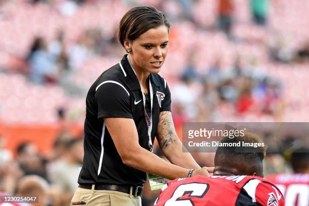 Offensive assistant Katie Sowers of the Atlanta Falcons walks with wide receiver Corey Washington prior to a preseason game against the Cleveland...