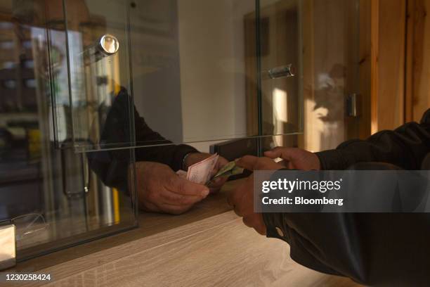 Customer exchanges Tunisian dinar banknotes at a foreign currency exchange bureau in Tunis, Tunisia, on Monday, Dec. 21, 2020. Tunisia will receive a...