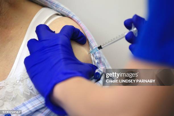 Nurse Practitioner Terri Welch administers a dose of the Pfizer-BioNTech Covid-19 vaccine to a patient at the Haxby and Wigginton Group Medical...