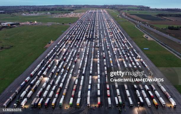 An aerial view shows lines of freight lorries and heavy goods vehicles parked on the tarmac at Manston Airport near Ramsgate, south east England on...