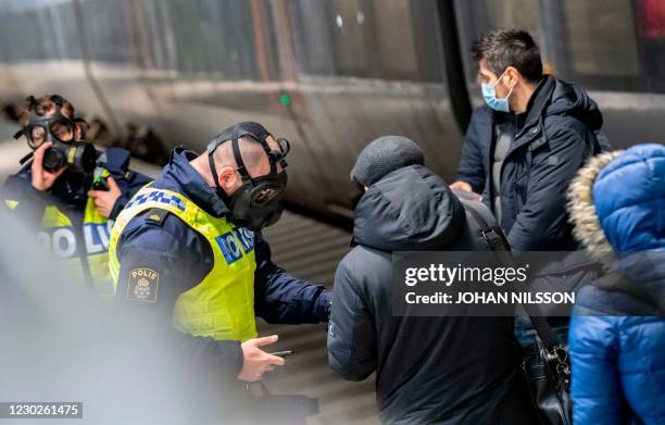 Travellers from Denmark are controlled by Swedish police wearing protective masks at the border control point at Hyllie station on Decmber 22, 2020....