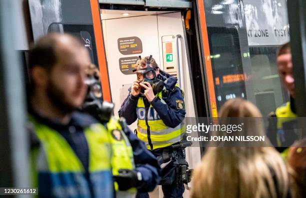 Swedish policeman wears a protective mask at the border control point at Hyllie station on December 22, 2020. - The Swedish government shut the...