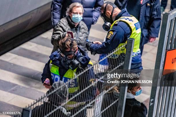 Travellers from Denmark are controlled by Swedish police wearing protective masks at the border control point at Hyllie station on Decmber 22, 2020....