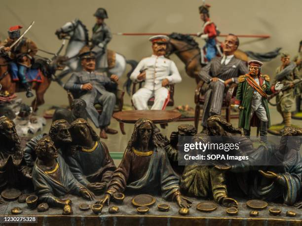 Bronze image of Jesus Christ and the apostles at the Last Supper against the background of miniature figures of the three leaders of the anti-Hitler...