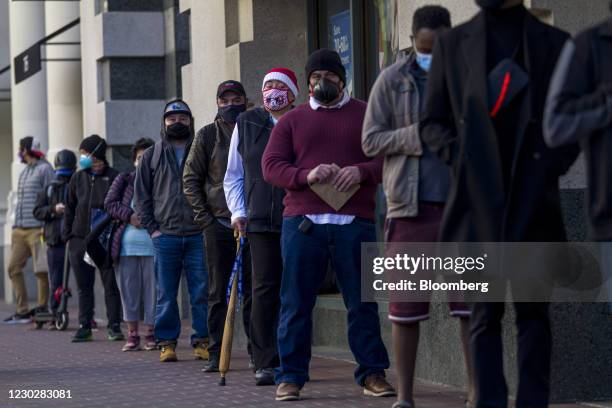 Shoppers wearing protective masks wait in line to enter a Ross Stores Inc. Store in San Francisco, California, U.S., on Wednesday, Dec. 23, 2020....