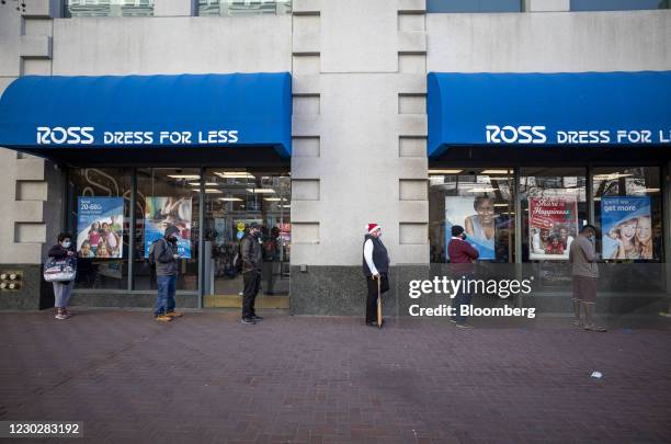 Shoppers wearing protective masks wait in line to enter a Ross Stores Inc. Store in San Francisco, California, U.S., on Wednesday, Dec. 23, 2020....