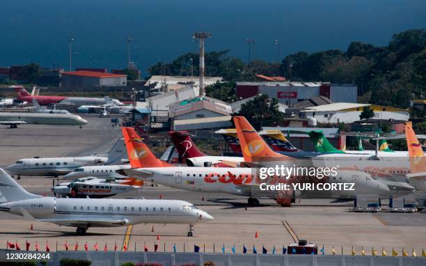 Commercial planes of different airlines and private jets sit on the tarmac at Simon Bolivar International Airport, in Maiquetia, Vargas State,...