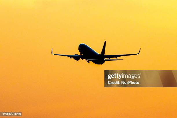 Silhouette of a departing passenger aircraft, a Ryanair low-cost airline Boeing 737-800 during sunset time. The departing airplane of the Irish...