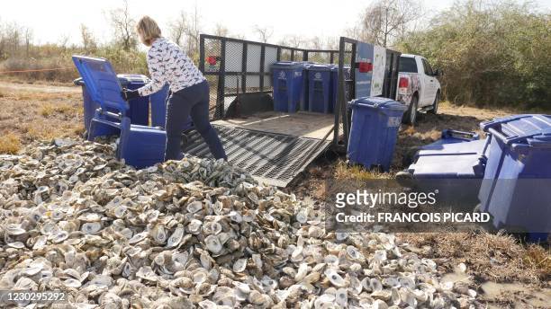 Shannon Batte unloads bins full of oyster shells at Red Bluff Road, a wasteland rented from the Port of Houston used as a curing site on December 21,...