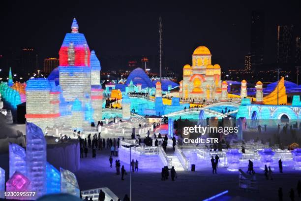 This photo taken on December 24, 2020 shows tourists looking at ice sculptures ahead of the Harbin International Ice and Snow Festival in Harbin, in...