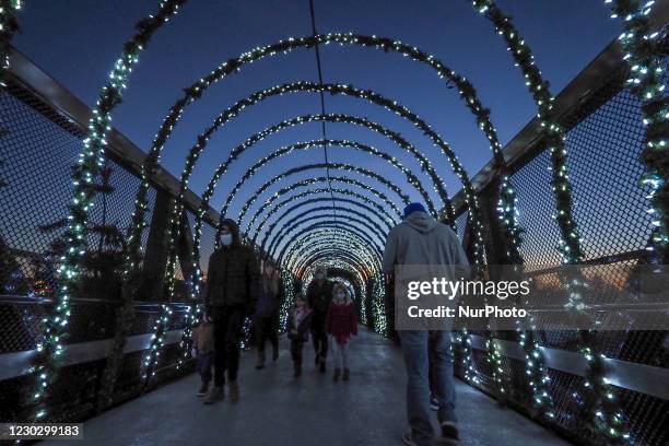 Visitors pass through a tunnel lit with Christmas lights during the annual PNC Festival of Lights Christmas Celebration at the Cincinnati Zoo and...