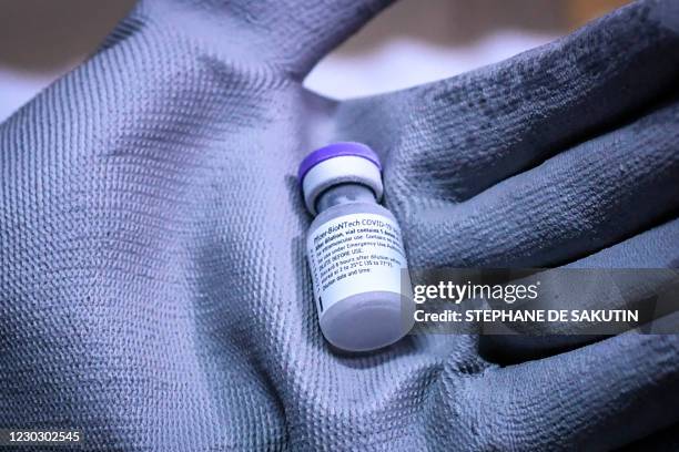 Worker shows a vial of Pfizer-BioNTech Covid-19 vaccine at the arrival of the first shipment in France in the AP-HP central pharmacy on the outskirts...