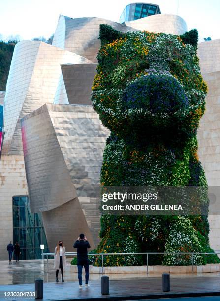 Artist Jeff Koons' "Puppy" is pictured sporting a flowery face mask at the Guggenheim Bilbao Museum in the Spanish Basque city of Bilbao on December...
