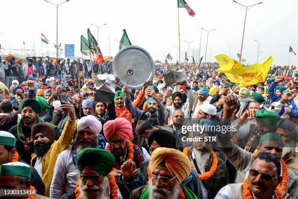 Farmers beat utensils during a protest against the central government's recent agricultural reforms as India's Prime Minister Narendra Modi addresses...