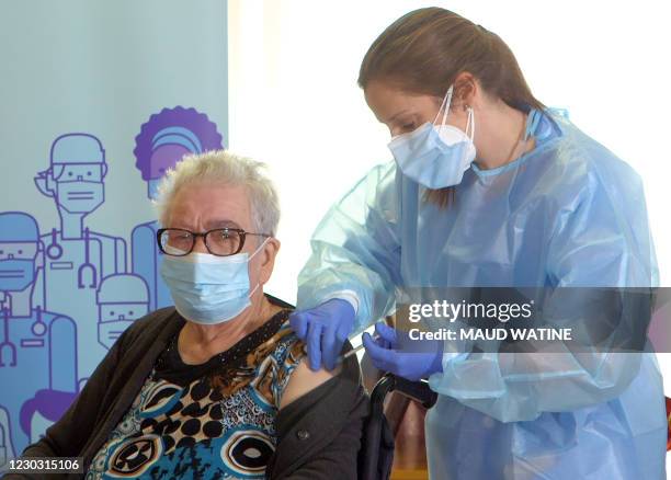 This video grab shows Josefa Perez a resident of Feixa Llarga nursing home for the elderly receiving a dose of the Pfizer-BioNTech Covid-19 vaccine...