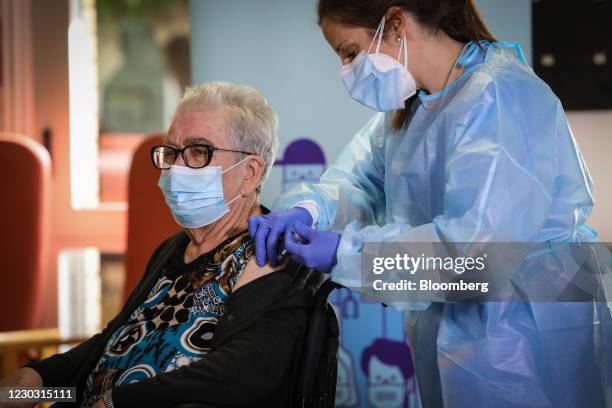 Idoia Crespo, a nurse, right, administers a dose of the Pfizer-BioNTech Covid-19 vaccine to Josefa Perez, a resident at the Feixa Llarga nursing...