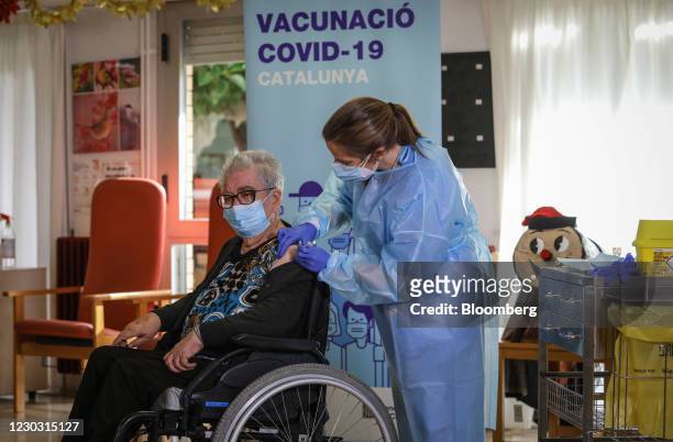 Idoia Crespo, a nurse, right, administers a dose of the Pfizer-BioNTech Covid-19 vaccine to Josefa Perez, a resident at the Feixa Llarga nursing...