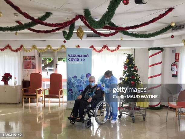 Josefa Perez a resident of Feixa Llarga nursing home for the elderly receives a dose of the Pfizer-BioNTech Covid-19 vaccine on December 27, 2020 in...