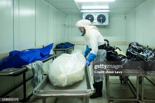 Hevra Kadisha" worker prepares bodies at a special morgue for COVID 19 before a funeral procession in the city of Holon on December 27, 2020 in...