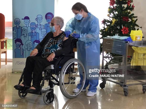 Josefa Perez a resident of Feixa Llarga nursing home for the elderly receives a dose of the Pfizer-BioNTech Covid-19 vaccine on December 27, 2020 in...