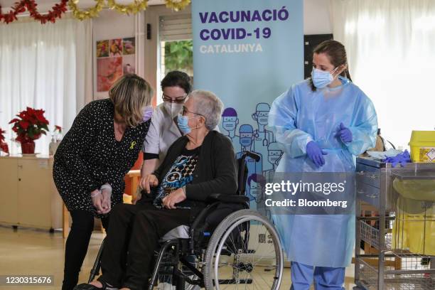 Attendees speak with Josefa Perez, a resident at the Feixa Llarga nursing home, second right, as she prepares to receive a dose of the...